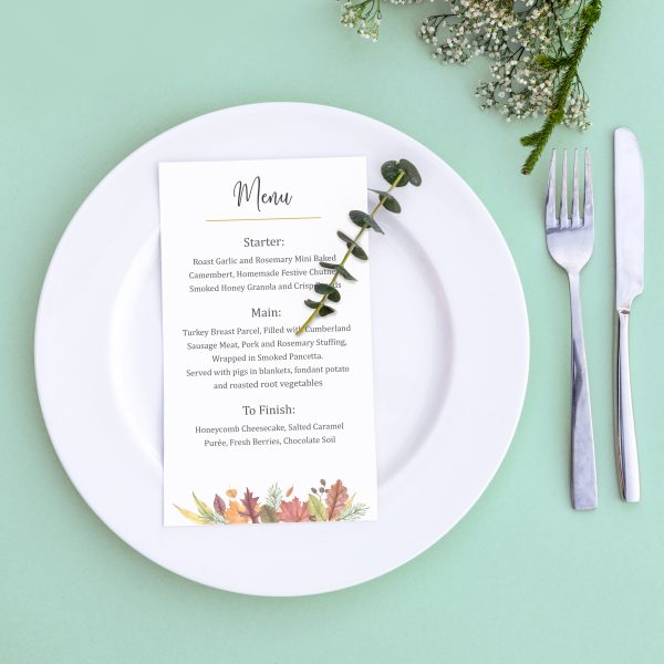 Dinner menu for a wedding or luxury evening meal. Table setting from above. Elegant empty plate, cutlery and flowers.