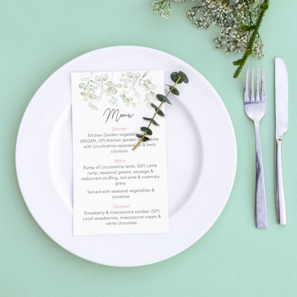 Dinner menu for a wedding or luxury evening meal. Table setting from above. Elegant empty plate, cutlery and flowers.