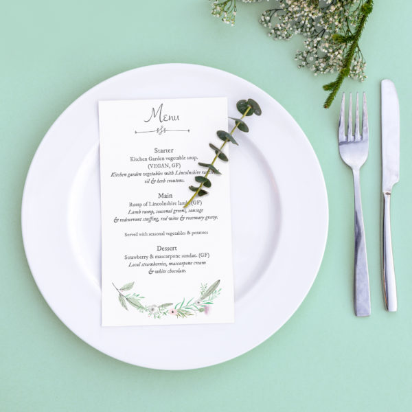 Dinner menu for a wedding or luxury evening meal. Table setting from above. Elegant empty plate, cutlery and flowers.