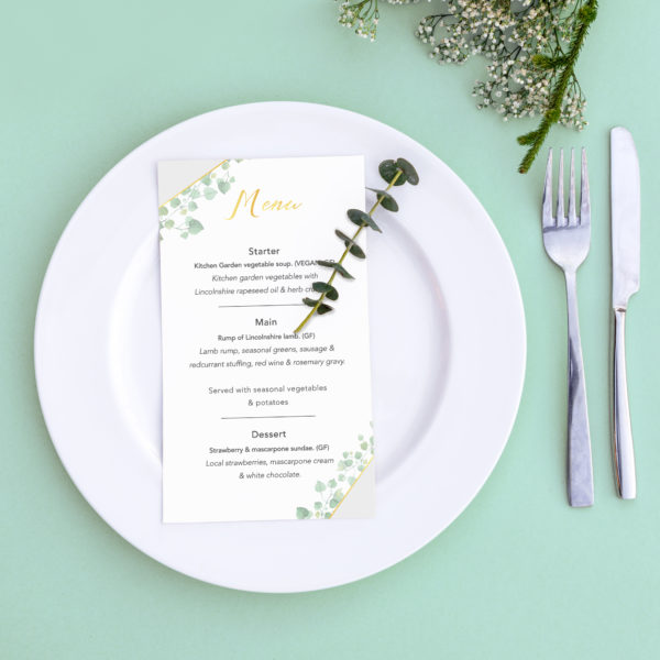 Dinner menu for a wedding or luxury evening meal. Table setting from above. Elegant empty plate, cutlery and flowers.