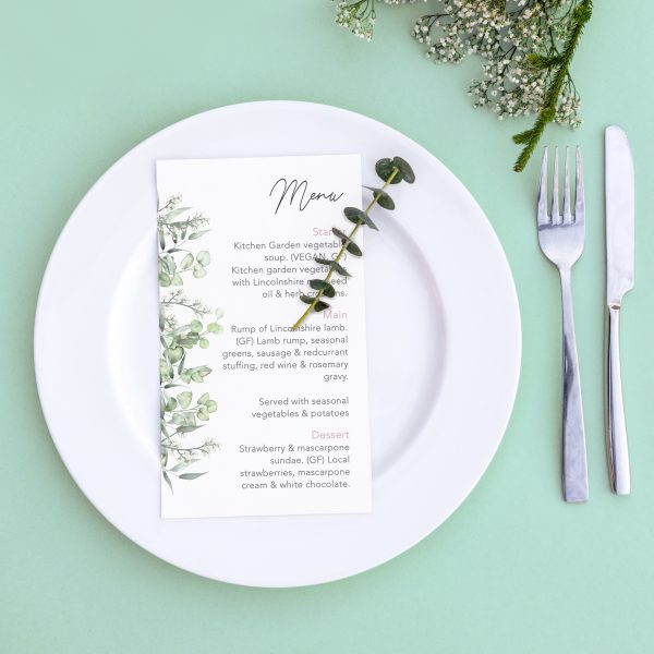 Dinner menu for a wedding or luxury evening meal. Table setting from above. Elegant empty plate, cutlery and flowers.