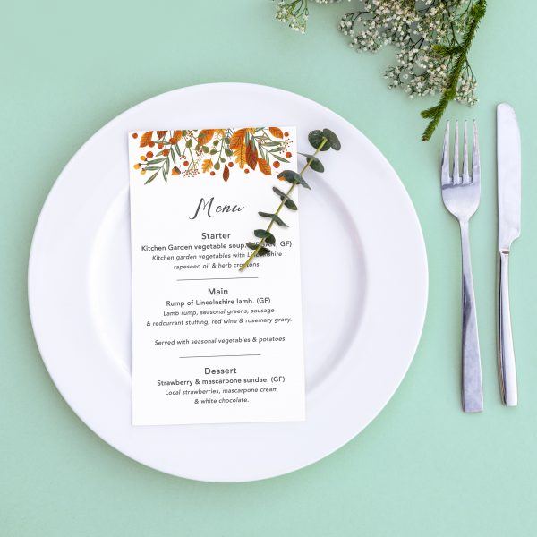 Dinner menu for a wedding or luxury evening meal. Table setting from above. Elegant empty plate, cutlery and flowers.