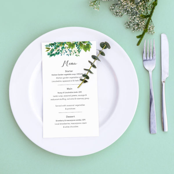 Dinner menu for a wedding or luxury evening meal. Table setting from above. Elegant empty plate, cutlery and flowers.