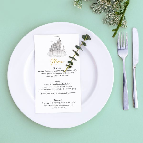 Dinner menu for a wedding or luxury evening meal. Table setting from above. Elegant empty plate, cutlery and flowers.