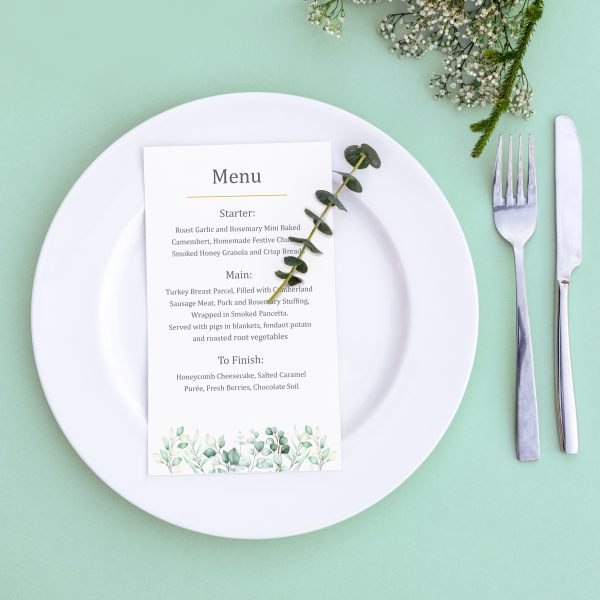 Dinner menu for a wedding or luxury evening meal. Table setting from above. Elegant empty plate, cutlery and flowers.