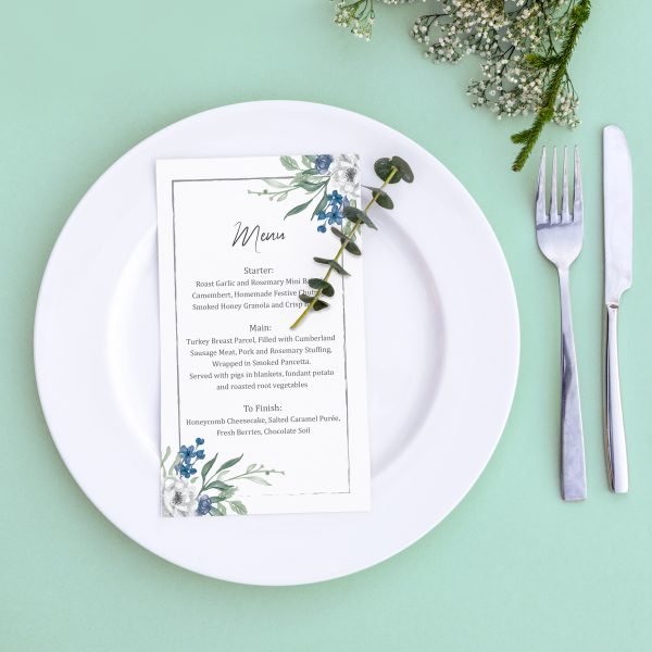 Dinner menu for a wedding or luxury evening meal. Table setting from above. Elegant empty plate, cutlery and flowers.